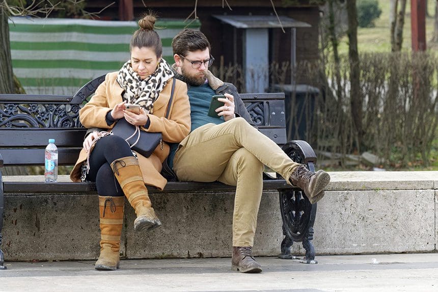 Couple both looking at their phones.