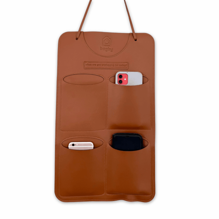 Brown leather hanging organizer with pockets for devices, minimalist design with slots for phone, tablet, and accessories