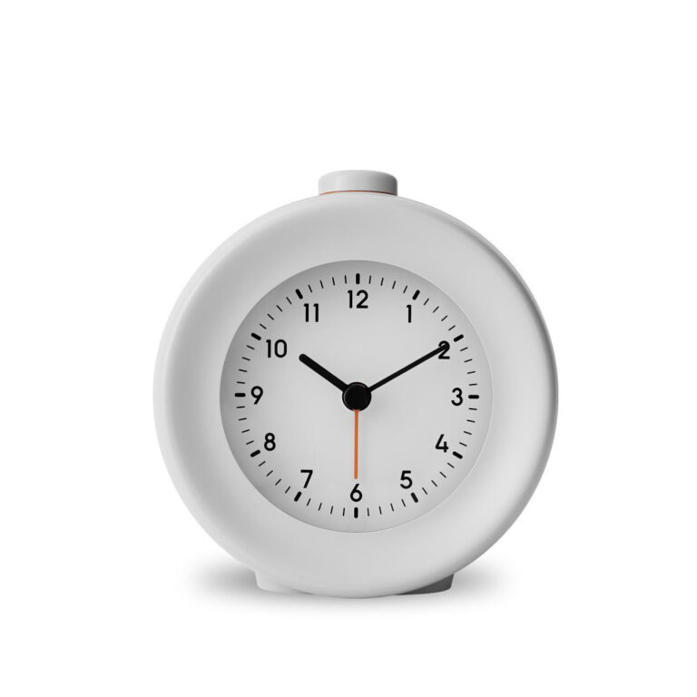 White minimalist round analog alarm clock with black numbers and hands, set against a neutral background