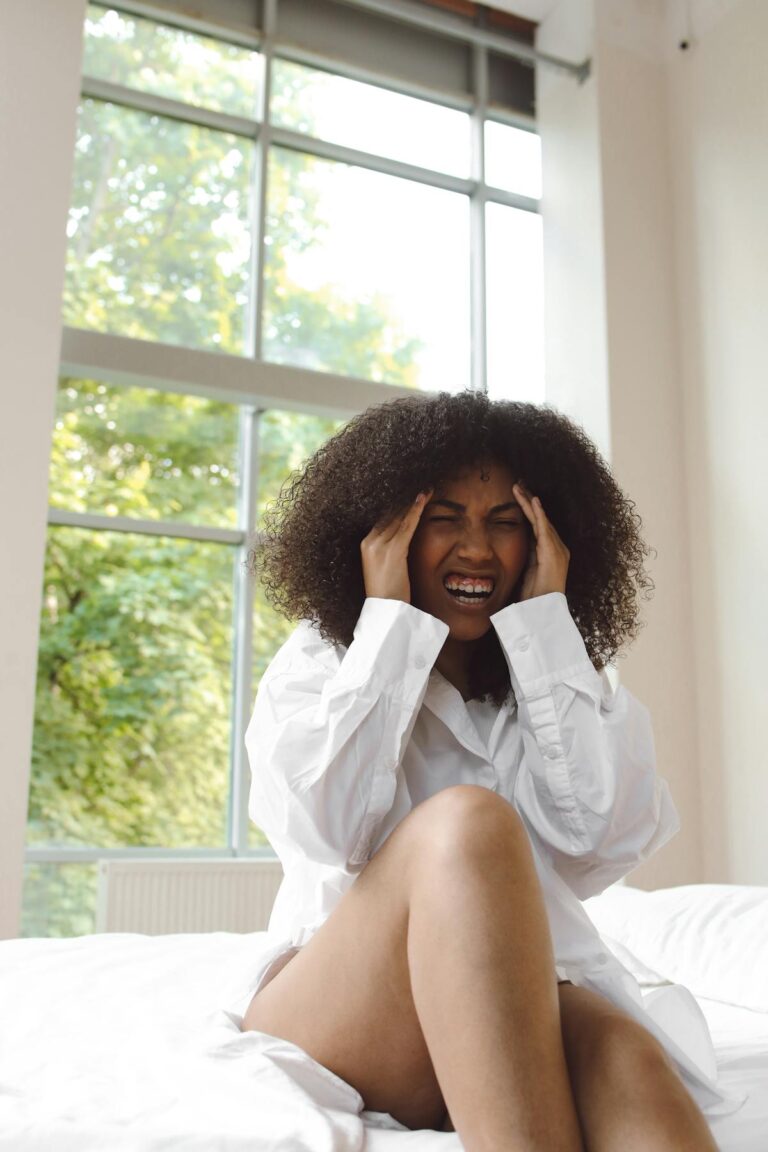 Person holding head showing fatigue or headache experiencing EMF sensitivity symptoms