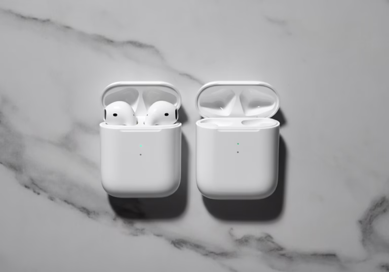 Two white Apple AirPods in their charging case, resting on a marble-textured background in black and white