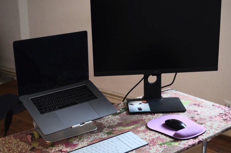 Person using laptop on desk with external keyboard